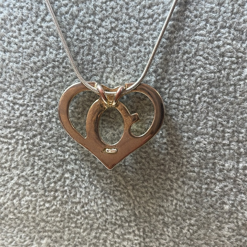 Heart necklace in silver tone and  gold tone, adorned with sparkly rhinestones.